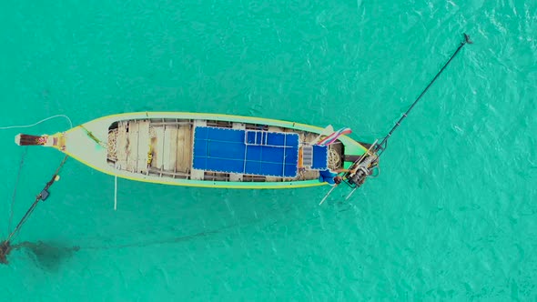 Aerial view or top view of long-tailed boat is floating on the emerald sea. Calm andaman sea at Phuk