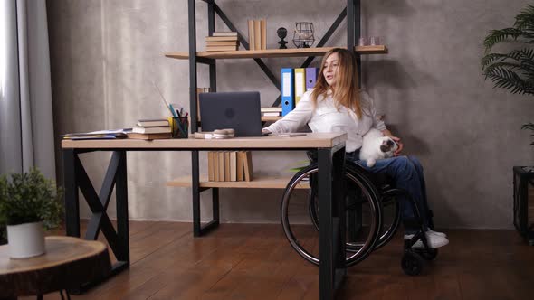 Disabled Woman with Cat Working on Laptop at Home