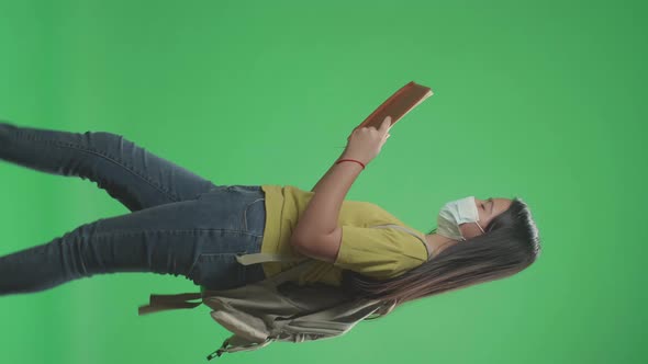 Asian Girl Student Wearing A Mask, Looking Book While Walking To School On Green Screen