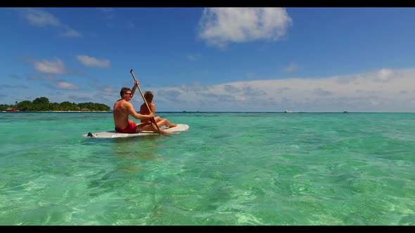 Family of two in love on tranquil tourist beach lifestyle by blue ocean with white sand background o