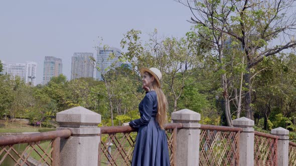 Smiling Woman on Vacation Staying and Relax on Bridge Over River