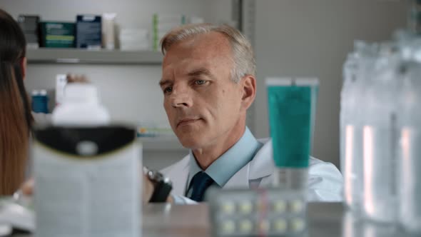 Male Pharmacist Drives Medical Audit in Interior of Modern Pharmacy
