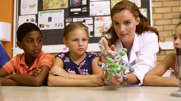 Teacher explaining a kids about molecular model in laboratory