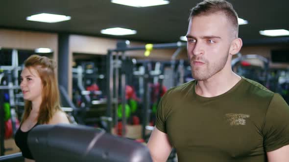 Handsome Muscular Man is Walking on the Treadmill in the Sport Gym Warming Up Before Training