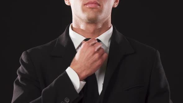 Cropped Shot of the Hands of a Guy Who Straightens His Tie