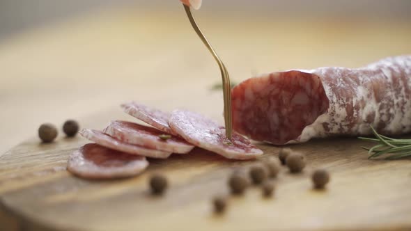 Twig of Fresh Rosemary and Seeds of Pepper Lying on Scratched Board Near Delicious Sliced and Whole