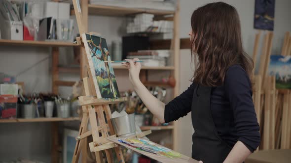 Artist Creating Landscape Painting in Studio