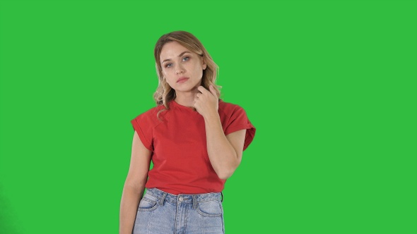 Young woman with blond hair in red T-shirt looking at camera