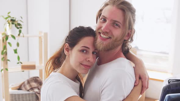 Young Happy Caucasian Pair Embracing Each Other in Their New Flat in Slowmotion