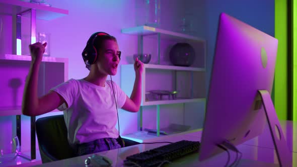 Beautiful Gamer Winning Esport Competition Online in Neon Lights at Home Closeup