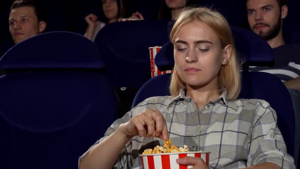 Attractive Female Eating Popcorn at Movie Premiere at the Cinema