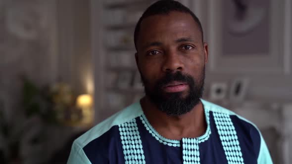 Close-up Portrait of an African-American Man at Home in a Bright Office. A Confident Student Guy