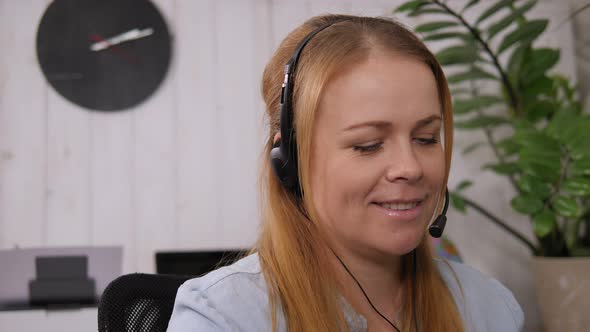 Smiling Woman Working As Customer Support Operator with Headset in a Call Center