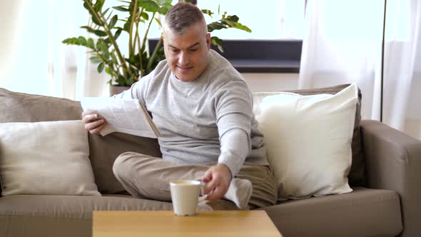 Man Reading Newspaper and Drinking Coffee at Home 29