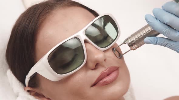 Lovely Female in Protection Glasses Having Laser Theraphy