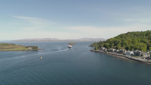 Aerial shot revealing the sea entrance to Oban with Ferry departing towards Mull