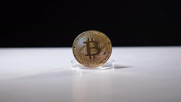 Golden Bitcoin on White Table on Black Background