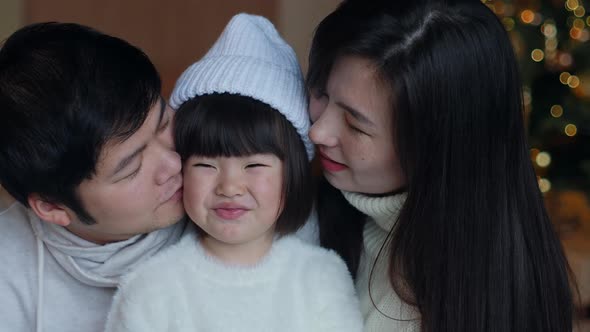 Korean Family with Daughter Sitting in White Sweaters Christmas Tree