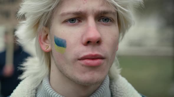 Close up portrait of young caucasian man with Ukrainian flag painted on his cheek. Shot with RED hel