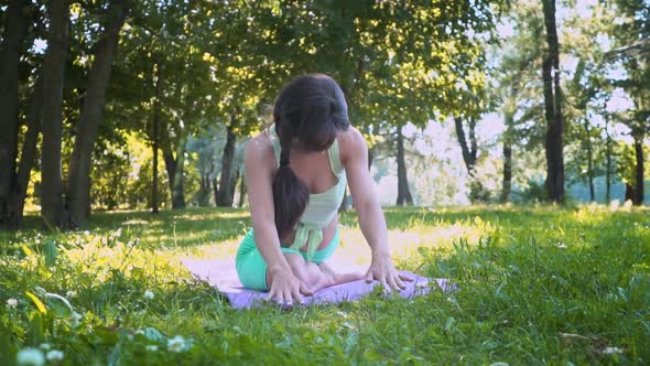 Caucasian Woman Sportswear Trains Asana Yoga Green Lush Grass Sunny Weather Doing Lotus for