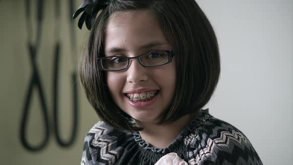 Slow motion of young girl in doctors office smiling big.