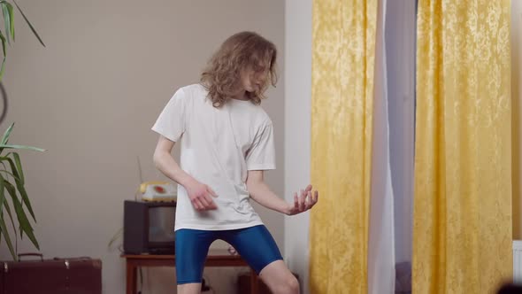 Absorbed Skinny Young Man Imitating Playing Guitar in Retro House Indoors