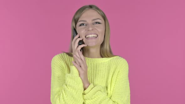 Happy Young Girl Talking on Phone, Pink Background