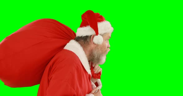 Santa claus with finger on lips carrying sack