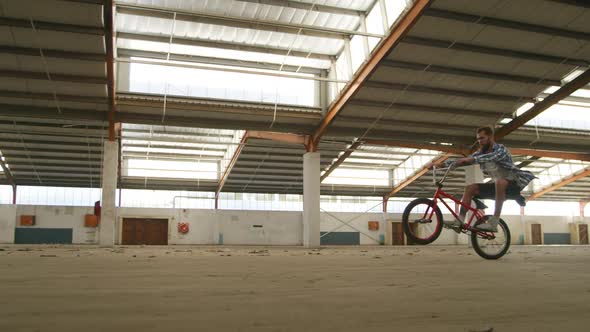 BMX riders in an empty warehouse