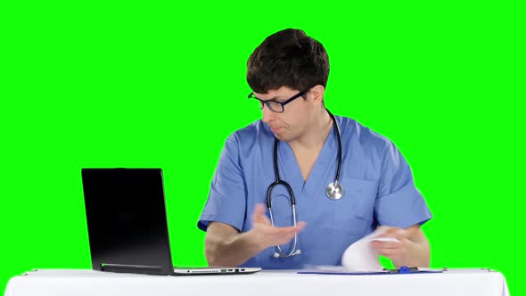 Angry Doctor Posing at Table. Problems with Documents. Green Screen