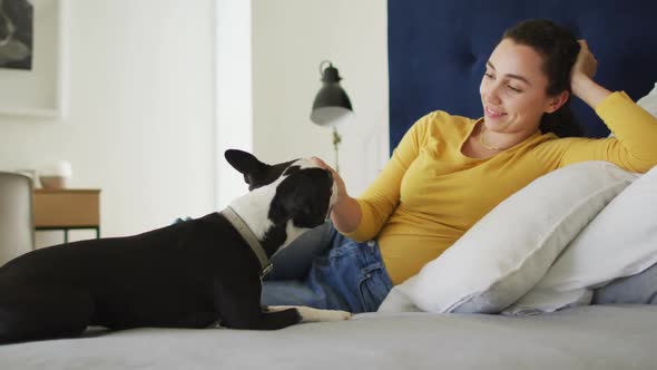 Caucasian woman is playing with his dog at home