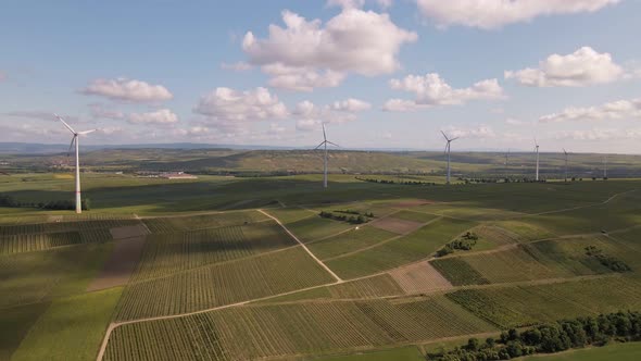 A wind park in the wine fields of Rhineland-Palatinate, Germany. Wide angle aerial fly through shot