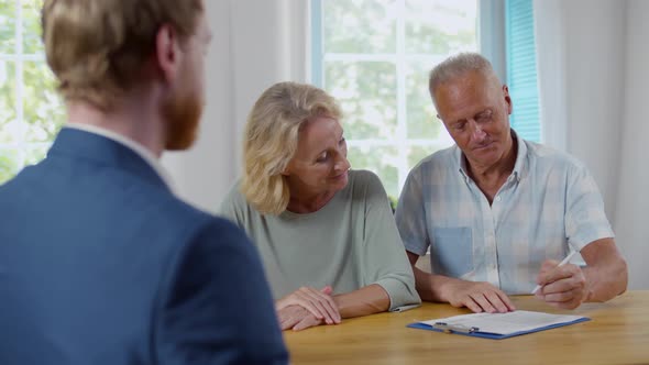 Happy Senior Couple Sign Medical Insurance Contract in Agency