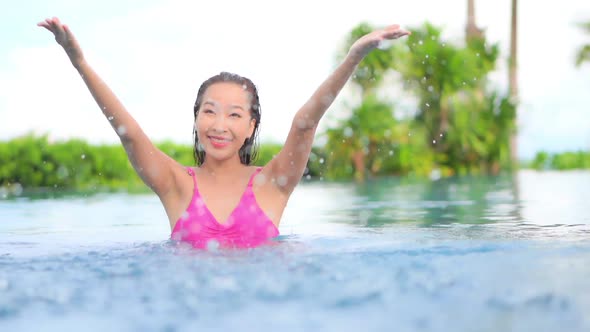 Young asian woman enjoy around outdoor swimming pool for leisure