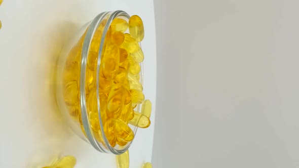 Vertical orientation video: Omega 3 (fish oil). Organic supplements vitamins yellow capsules