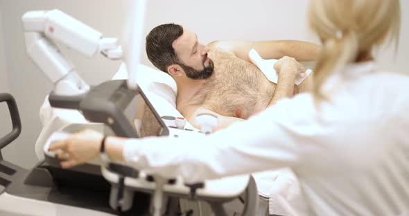 Doctor Examining Liver of Male Patient with Ultrasound Scan in Clinic