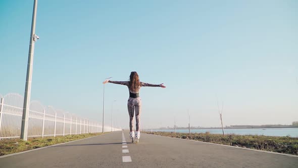 Athletic Slim Rides Girl Roller Skating Happily Raises His Hands