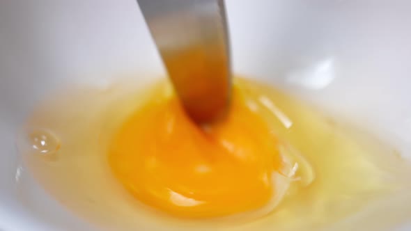 Closeup Knife Beating Egg White and Yolk in Slow Motion