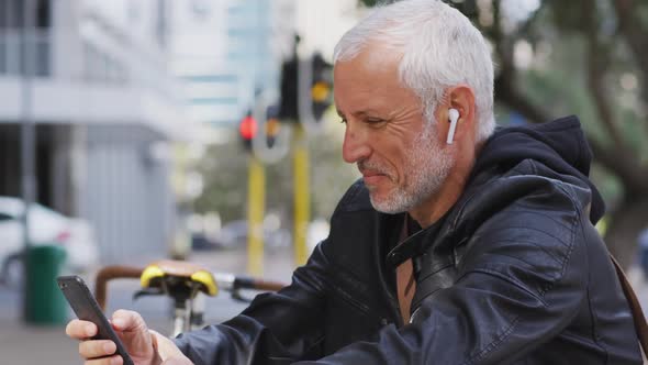 Caucasian man out and about in the city street using his smartphone