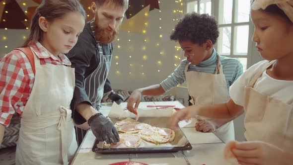 Kids Adding Ham to Pizza before Baking on Culinary Class