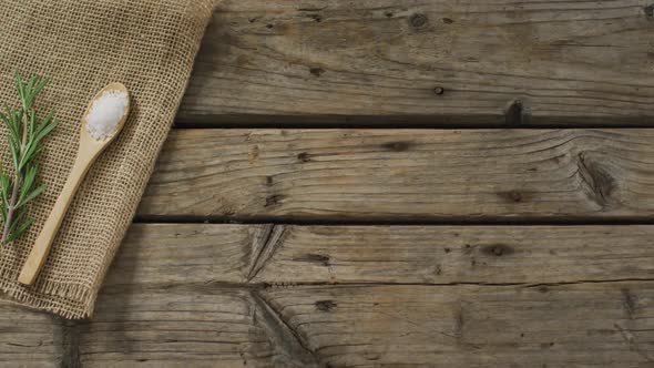 Video of rosemary twig and spoon of salt on wooden background