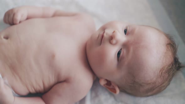 Infant Boy with Muscle Hypertonus and Mother Doing Massage