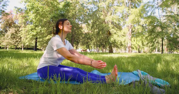 30 Years Old Woman Stretcing Muscles in City Park