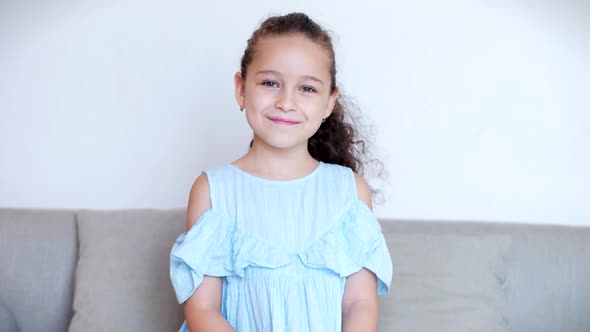 Portrait Funny Little Girl Smiling Chil Looking at Camera Are Sitting on the Couch at Home, Cute Kid