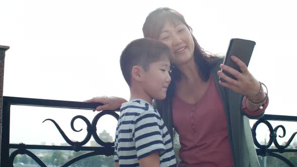 Asian Mother and Little Son Taking Selfie with Smartphone