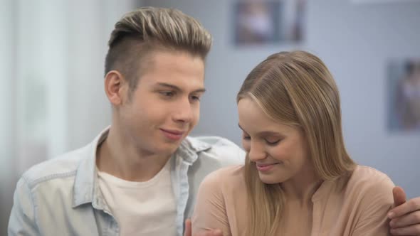 Teenage Boy Tenderly Hugging His Beautiful Lady Shoulders Looking in Her Eyes