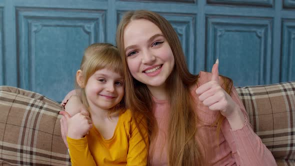 Portrait of Satisfied Child Kid Daughter with Young Mother Hugging Embracing Showing Thumbs Up