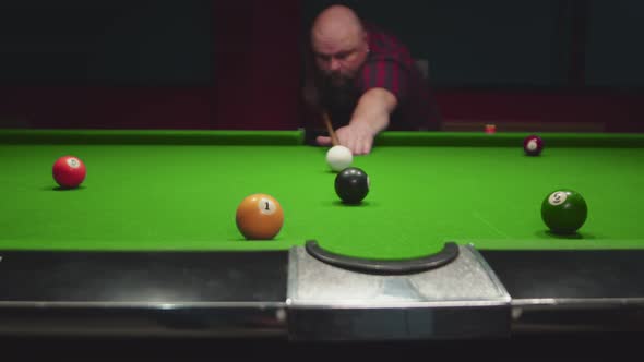 Man is Playing in Billiard Club Hits White Ball with Cue It Rolls and Knocks Against Black One Black