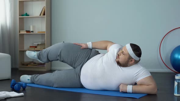 Hardworking Fat Man in Sportswear Doing Leg Exercises at Home, Burning Calories