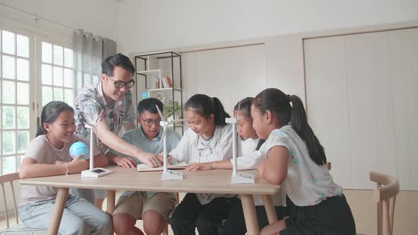 Middle School Classroom: Enthusiastic Teacher Explains To A Young Children How Wind Turbines Work